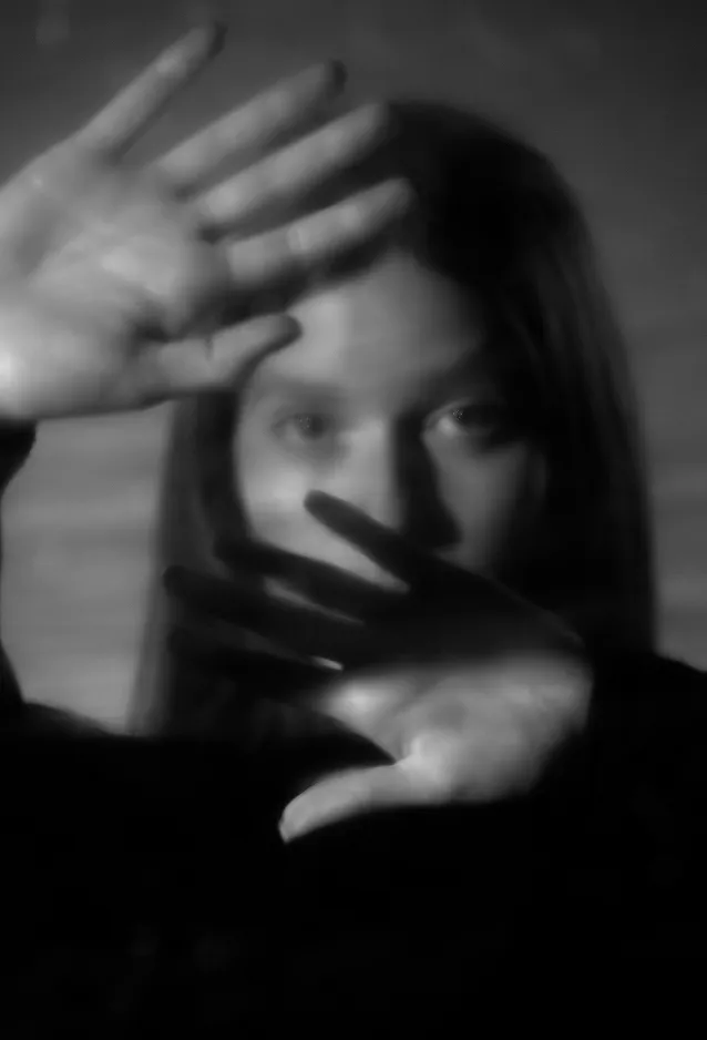 Person shielding their face with their hands