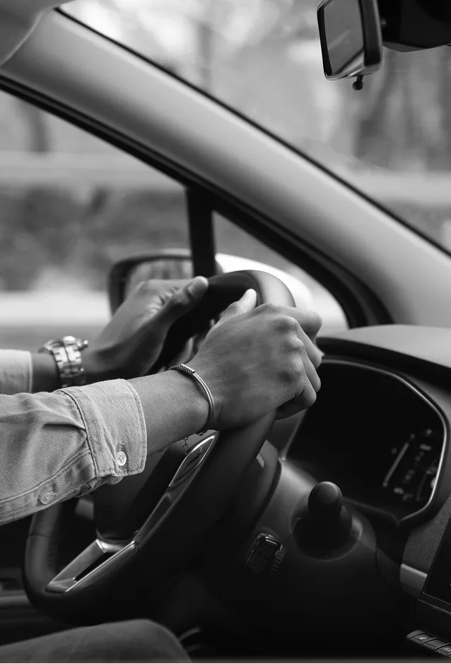 Person holding a car steering wheel